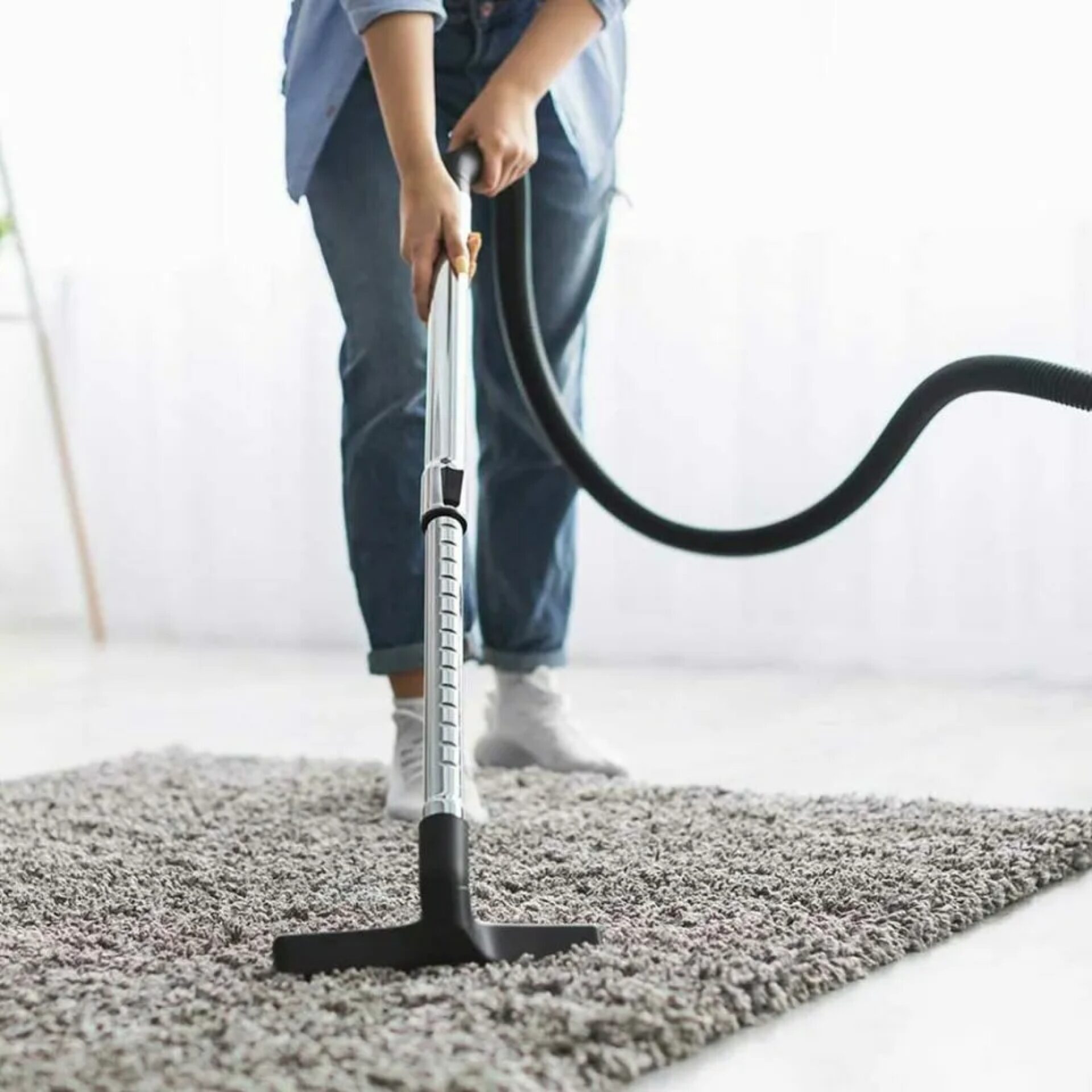 Woman vacuuming an area rug